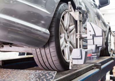 Closeup of tire clamped with aligner undergoing auto wheel align